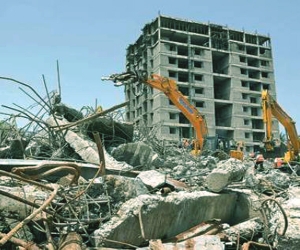 A large building being demolished with a wrecking ball in an dammam area."