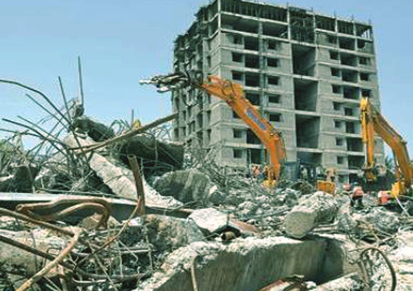A large building being demolished with a wrecking ball in an dammam area."